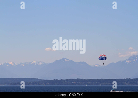 Parasailing in Seattle, USA, mit Blick auf die Rocky Mountains in der Ferne Stockfoto