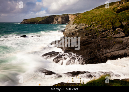 Surfen Sie über Felsen bei Flut an der kornischen Küste Trebarwith Strand brechen Stockfoto