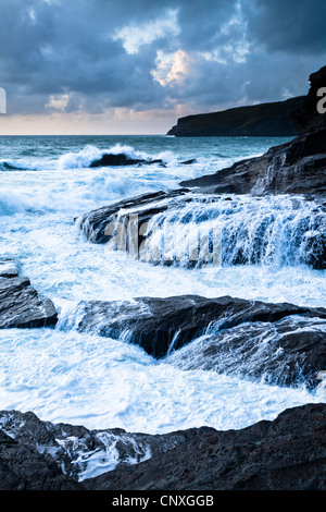 Surfen Sie über Felsen bei Flut an der kornischen Küste Trebarwith Strand brechen Stockfoto