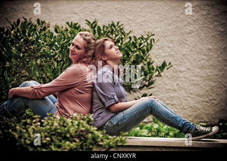 Mutter und Tochter sitzen im Garten hinter dem Haus Stockfoto