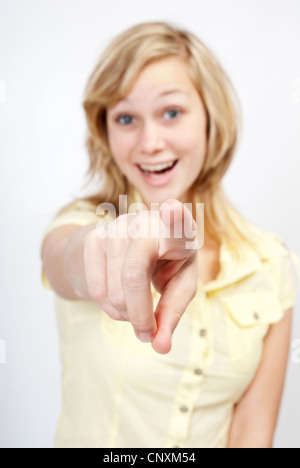 Junge schöne Frau zeigt mit dem Finger in Richtung des Betrachters. Stockfoto