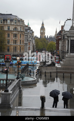 Touristen in Trafalgar Square auf einer nassen Apriltag Stockfoto