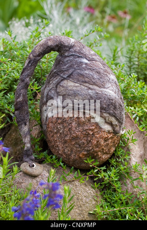 "gefühlte Stein Troll" dient als Gartendekoration: ausgestatteten mit Kappen gefilzte Wolle Naturstein steht in einem Blumenbeet, Deutschland