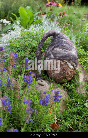 "gefühlte Stein Troll" dient als Gartendekoration: ausgestatteten mit Kappen gefilzte Wolle Naturstein steht in einem Blumenbeet, Deutschland