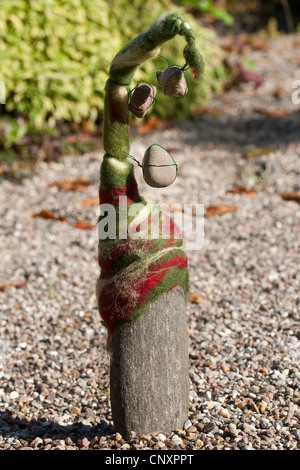 "gefühlte Stein Troll" dient als Gartendekoration: Naturstein ausgestattet mit Kappen gefilzte Wolle steht auf Kies-Boden, Deutschland