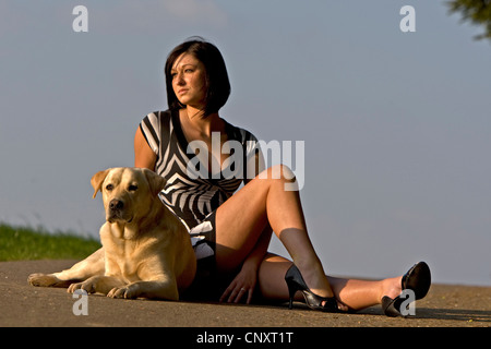 Labrador Retriever (Canis Lupus F. Familiaris), liegend auf Pfad neben einer attraktiven Frau kurze Kleid Stockfoto