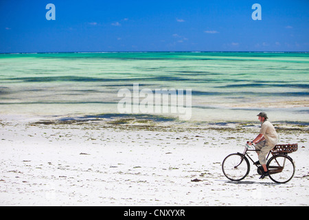 junger Mann mit dem Fahrrad am tropischen Strand, Tansania, Sansibar Stockfoto