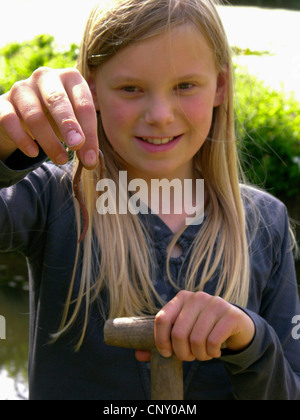 gemeinsamen Regenwurm, Regenwurm; BVG-Wurm, Tau Wurm (Lumbricus spec.), Mädchen mit einem Earthwom in der Hand, Deutschland Stockfoto