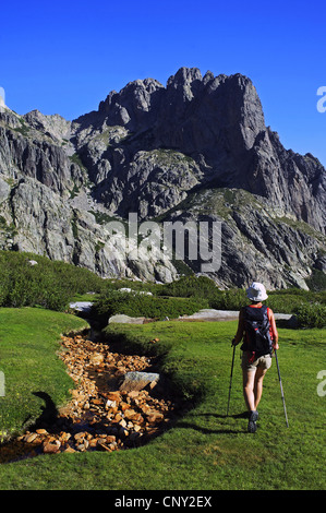 weibliche Wanderer nächste getrocknete Gebirgsbach vor Bergkulisse, Frankreich, Korsika, Restonica, Corte Stockfoto