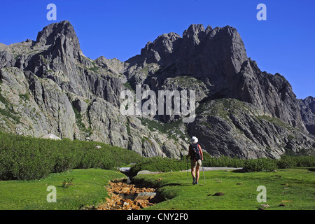 weibliche Wanderer nächste getrocknete Gebirgsbach vor Bergkulisse, Frankreich, Korsika, Restonica, Corte Stockfoto