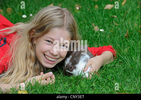 Hauskaninchen (Oryctolagus Cuniculus F. Domestica) ist elf Jahre alt Mädchen einen niedlichen Häschen kuscheln Stockfoto