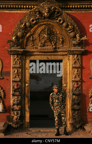 Nepalesische Polizisten bewacht das goldene Tor des königlichen Palastes in Bhaktapur Durbar Square in Bhaktapur, Nepal. Stockfoto