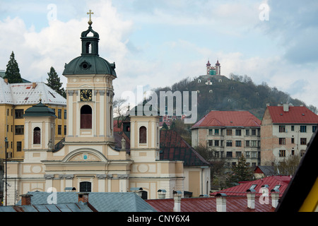 Pfarrkirche in Banska Stiavnica mit Kalvarienberg im Hintergrund, Slowakei Stockfoto