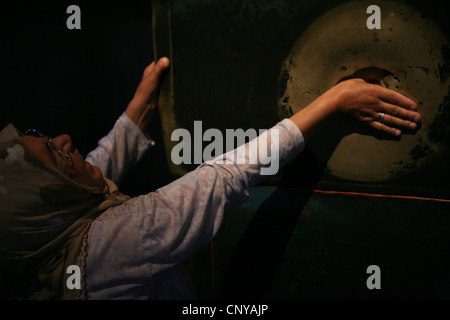 Türkin dreht den Daumen in das Loch in der Spalte weinend in der Hagia Sophia in Istanbul, Türkei. Stockfoto