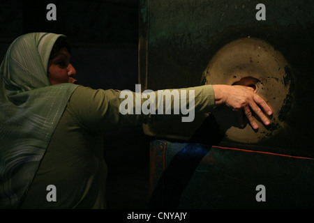 Türkin dreht den Daumen in das Loch in der Spalte weinend in der Hagia Sophia in Istanbul, Türkei. Stockfoto