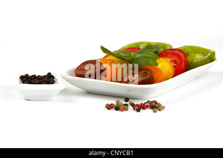 Verschiedene Sorten von Bio Tomatenscheiben auf einem Teller vor weißem Hintergrund Stockfoto