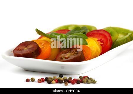 Verschiedene Sorten von Bio Tomatenscheiben auf einem Teller vor weißem Hintergrund Stockfoto