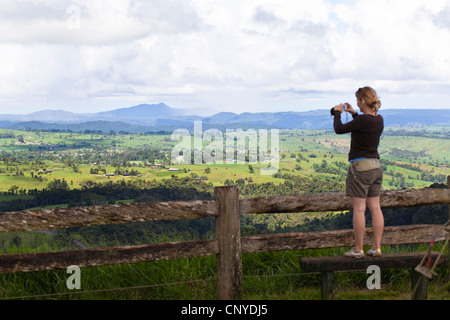 junge Frau auf einer Bank ein Fotografieren von sanften Hügeln der Atherton Tablelands, Australien, Queensland Atherton Tablelands Stockfoto