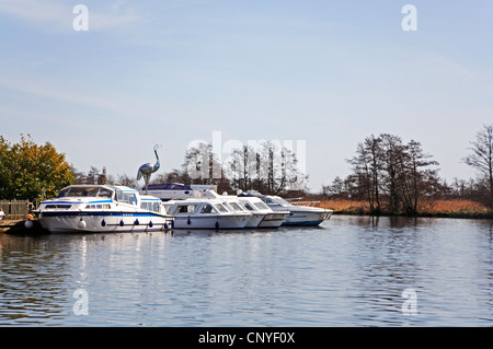 Mieten Sie Boote auf dem Fluss Bure mit Reiher Skulptur Horning, Norfolk, England, Vereinigtes Königreich. Stockfoto