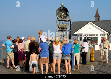 Suffolk - Southwold Pier - Sommer Menschenmenge wartete, die komische Wasseruhr zu jeder vollen Stunde führen zu sehen - Sonnenlicht blauen Himmel Stockfoto