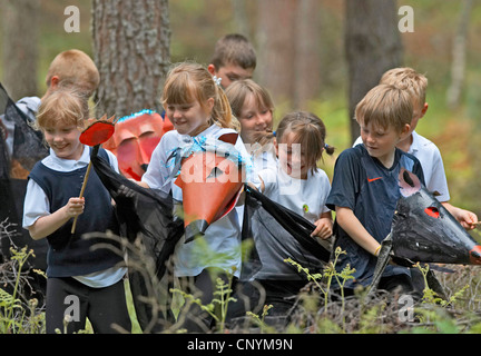 Gruppe von Kindern in einem Wald mit Masken von Tieren der örtlichen Fauna, Großbritannien, Schottland Stockfoto