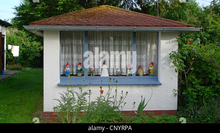 sieben Garten Zwerge und Schneewittchen in eine Zeile im Fenster von einem Sommerhaus, Deutschland Stockfoto