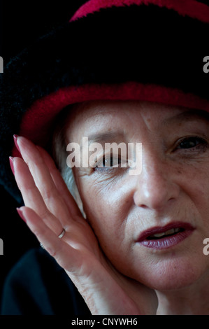 Mittlere gealterte Frau mit roten und schwarzen Hut Stockfoto