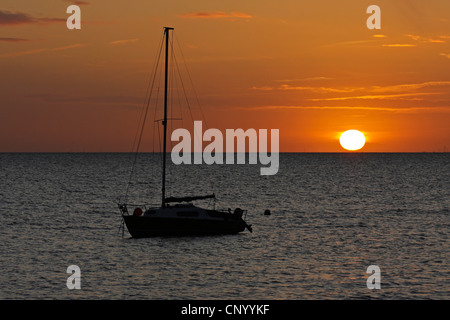 Segelboot auf dem Meer vor Sonnenaufgang, Deutschland, Schleswig-Holstein, Sylt Stockfoto