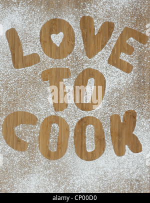 Liebe zu Kochen Eindruck in Puderzucker auf einem Holzbrett Stockfoto