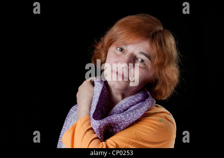 Mittlere gealterte Frau mit lila Schal Stockfoto