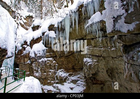 Pass mit einem Geländer entlang einer Wand ein Rock Canyon mit malerischen Eiszapfen, Österreich, Vorarlberg, Kleinwalsertal Stockfoto