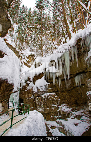 Pass mit einem Geländer entlang einer Wand ein Rock Canyon mit malerischen Eiszapfen, Österreich, Vorarlberg, Kleinwalsertal Stockfoto