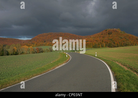 Landstraße in eine herbstliche Landschaft mit Ruinen der Burg Gleichenstein, Deutschland, Thüringen, Martinfeld Stockfoto