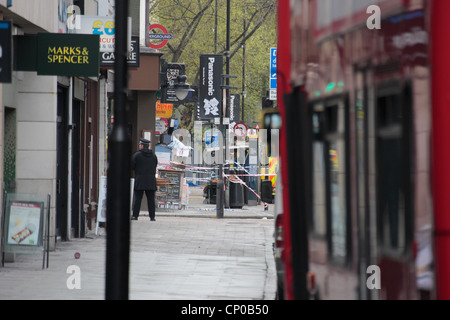 Ein Polizist steht auf einer Schnur während einer Belagerung auf Tottenham Court Road, Freitag, 27. April 2012 Stockfoto