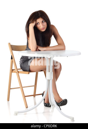 Mädchen sitzen auf einem Stuhl neben dem Tisch Stockfoto