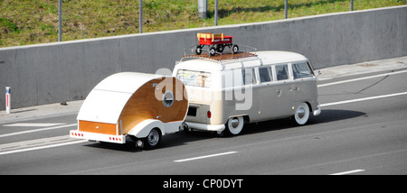 Ungewöhnlicher VW Wohnmobil mit Minianhänger auf Dachträger Schleppen Teardrop Micro Wohnmobil-Wohnmobil-Wohnmobil entlang der M25 Autobahn Essex England Großbritannien Stockfoto