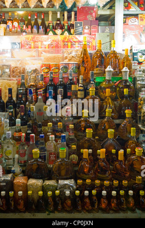 Vertikale Reihen von verschiedenen Flaschen Alkohol, einschließlich Wein oder Rượu Rắn Schlange, zum Verkauf in Vietnam hautnah. Stockfoto