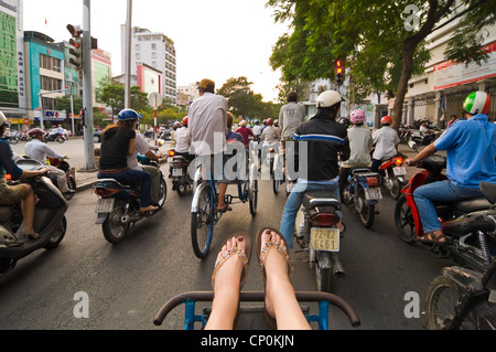 Horizontale Ansicht eines westlichen Touristen auf Fahrradrikscha Reisen durch dichten Verkehr auf den verrückten Straßen von Ho-Chi-Minh-Stadt