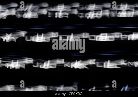 Schwarze Tastatur mit verschwommenen beleuchtet beleuchtete weiße Buchstaben auf Tasten im Dunkeln Stockfoto