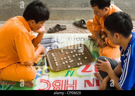 Horizontale Nahaufnahme von vietnamesischen Männer spielen Cờ Tướng, ein beliebtes Spiel Schach-wie in Asien, am Straßenrand. Stockfoto