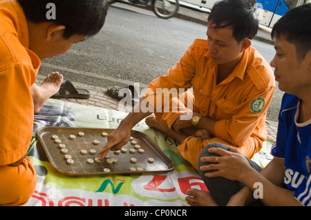 Horizontale Nahaufnahme von vietnamesischen Männer spielen Cờ Tướng, ein beliebtes Spiel Schach-wie in Asien, am Straßenrand. Stockfoto