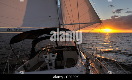 Eine Kreuzfahrt Yacht segeln Offshore bei Sonnenuntergang in der Coral Sea an der Ostküste von Australien. Ozeanien Stockfoto