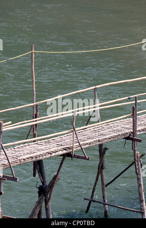 Eine fadenscheinige Bambus Fußgängerbrücke Passerelle de Bambous über Khan River, einem Nebenfluss des Mekong (Luang Prabang - Laos) geworfen Stockfoto