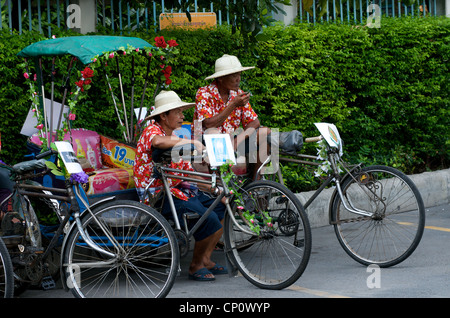 Cyclo oder mit dem Fahrrad-Rikscha-Fahrer nehmen Sie eine Bremse während der thailändischen Neujahrsfest auf Sukhumvit Road, Bangkok, Thailand. Stockfoto