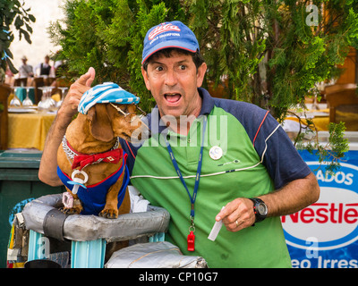 Cuban Street Performer posiert mit einer seiner ausgebildeten Dackel Hunde, die trägt einen Hut, Fliege und Gläser in Havanna, Kuba. Stockfoto