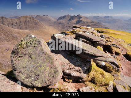 Sandsteinfelsen am Rande des Gipfels von Tom Na Gruagaich, Beinn Alligin, mit Gipfelns im Hintergrund Stockfoto