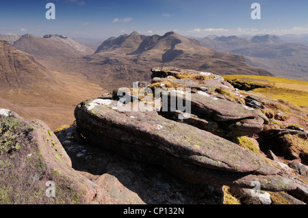 Sandsteinfelsen am Rande des Gipfels von Tom Na Gruagaich, Beinn Alligin, mit Gipfelns im Hintergrund Stockfoto