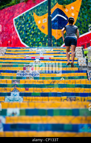 Eine Mädchen klettert die Selaron Treppen (Escadaria Selarón), ein Mosaik-Treppe aus der bunten Kacheln in Rio De Janeiro, Brasilien. Stockfoto