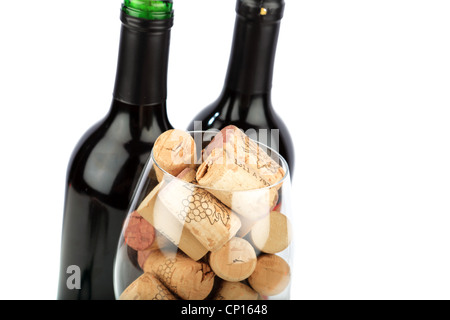 Weinglas mit Korken gefüllt stehen vor zwei Flaschen Wein und Trauben Stockfoto