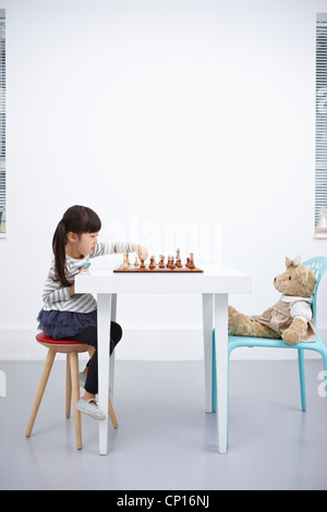 Ein Mädchen spielen Schachspiel mit Teddybär Stockfoto